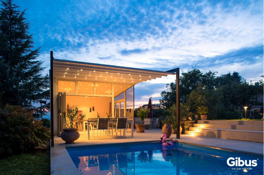 Maison contemporaine avec grandes fenêtres équipée de rideaux, volets extérieurs et store à toile tendue avec lambrequin, structure aluminium motorisée installée par des storistes spécialisés.
